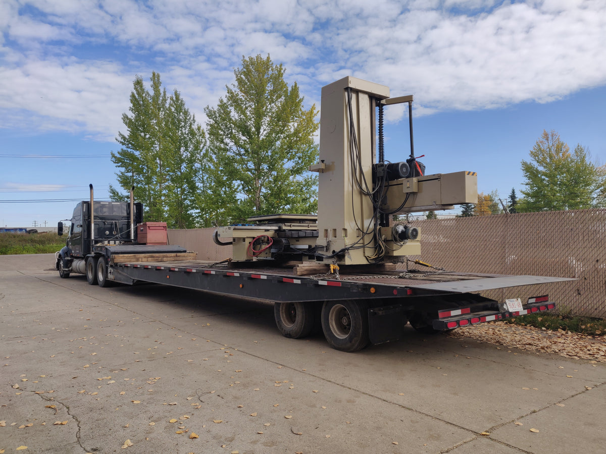 Industrial machinery moving truck transporting CNC equipment in Alberta